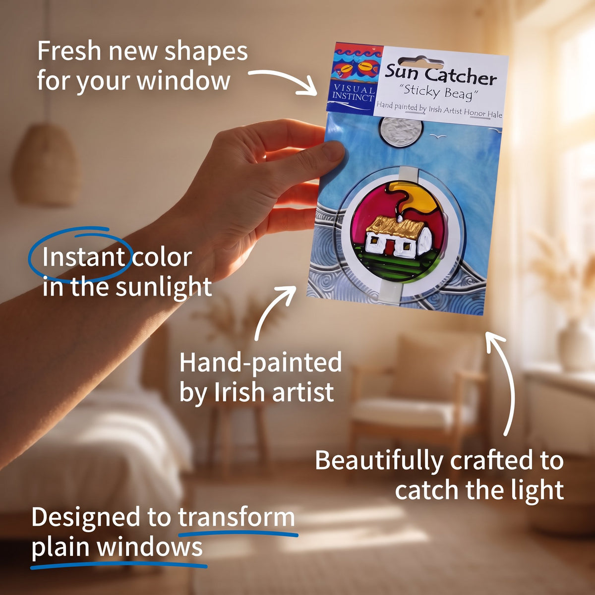 A hand holds a packaged 'Sun Catcher' sticky bead against a softly blurred warm interior background. The product card shows a round window sticker with a house and sun design, and multiple callout text overlays describe the product features and benefits.